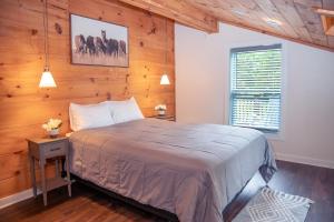 una camera da letto con un letto e una parete di legno di The Blue Barn at the MeadowCreek a Murfreesboro