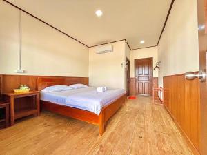 a bedroom with a bed and a wooden floor at DONDET Vixay Sunset And River View in Don Det