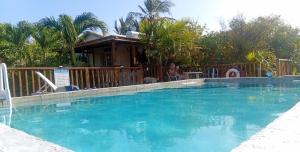a woman sitting in a chair next to a swimming pool at The Pool House in Saint Philip