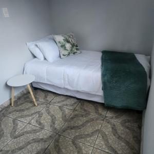 a room with a white bed and a table at Modern Comfort at 44 Biddulph in Harrismith