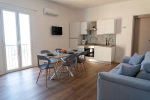 a kitchen and living room with a table and chairs at Amuri Holiday Home in Agrigento