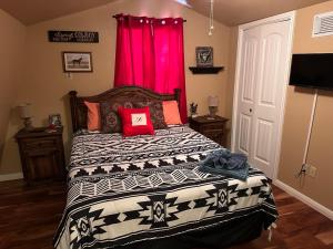 a bedroom with a large bed with a red curtain at Blessed Bull at the Creek in Bandera