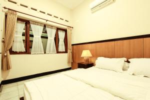 Postel nebo postele na pokoji v ubytování Griya Langen Guesthouse