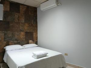 a bedroom with a bed with two towels on it at Apartamentos Marconela in San Mateo