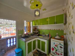 a green kitchen with a sink and a refrigerator at Casa Pearl in Chefchaouene
