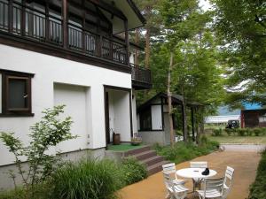 a table and chairs in front of a building at B&B Koyuki Hakuba in Hakuba