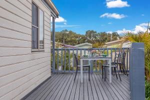 a wooden deck with a table and chairs on it at Lifestyle Villages Redhead in Redhead