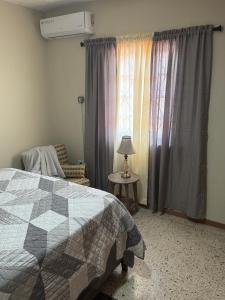 ein Schlafzimmer mit einem Bett und einem Stuhl und einem Fenster in der Unterkunft Constant Spring Oasis in Kingston