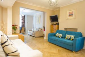 a living room with a blue couch and a tv at Chester Apartments in Chester