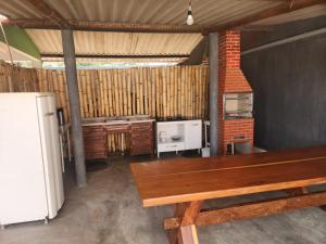 a kitchen with a wooden table and a refrigerator at Chalés Mirante da Lua Chalé 3 in Cavalcante