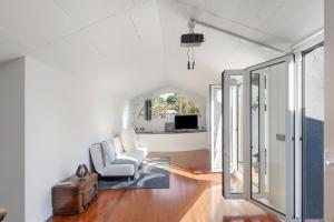 Una sala de estar con una silla y una mesa. en Villa Cela, en Masnou