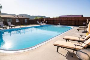 a large swimming pool with lounge chairs and chairs around it at Black Hills Station in Piedmont