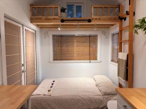 a bedroom with a bed in a room with a window at Riverwood Retreat-hot tub and cedar sauna on the river in Squamish
