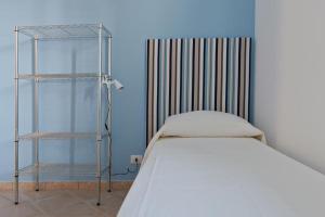 a small bedroom with a bed and a shelf at Casa Letizia in Porto Cesareo
