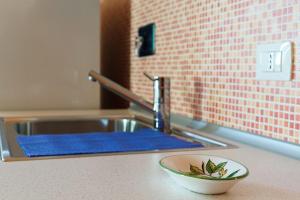 a kitchen sink with a bowl on a counter at Casa Letizia in Porto Cesareo