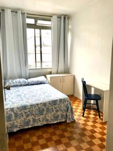 ein Schlafzimmer mit einem Bett, einem Schreibtisch und einem Stuhl in der Unterkunft Ap Demetrio Ribeiro in Água Boa