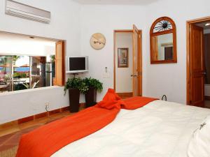 een slaapkamer met een groot bed en een oranje deken bij Casa Del Mar Los Cabos in San José del Cabo
