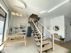 a room with a staircase and a table and a kitchen at 373 pool villa in Chiang Rai