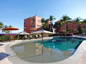 een zwembad met parasols en stoelen en een gebouw bij Casa Del Mar Los Cabos in San José del Cabo