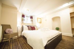 a bedroom with a large bed and a chair at Chester Apartments in Chester