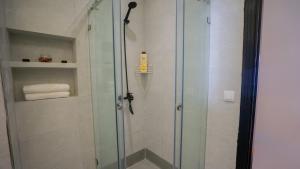 una ducha con puerta de cristal en un baño en Studio moderne, en Martil 10 fotos más