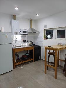 a kitchen with a white refrigerator and a table at Brisa Marina in Río Grande