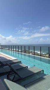 a swimming pool with a view of the ocean at Studio em Salvador- Vista Mar in Salvador