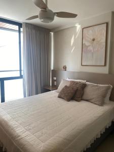 une chambre avec un grand lit blanc avec un ventilateur de plafond dans l'établissement Apto novo perto da UFF e Plaza, à Niterói 35 autres photos