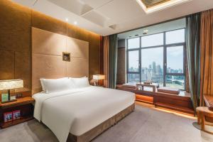 Postel nebo postele na pokoji v ubytování Chongqing Jiayu Emperor Hotel