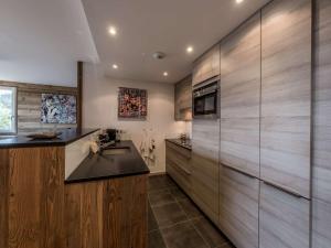 eine Küche mit Holzschränken und einer Spüle in der Unterkunft Courchevel 1850 - Appartement 4 pers - Skis aux pieds avec Parking et Wifi - FR-1-631-232 in Courchevel