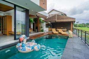an inflatable swimming pool in the backyard of a house at Kairos Villa Ubud by Omkara Experience in Ubud