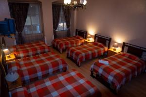 a room with three beds in a room at Hotel Rosim by Rodelu in Latacunga