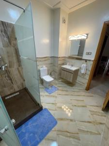 a bathroom with a shower and a toilet and a sink at Al Kawtar in Mansouria +5 photos