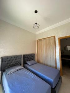 a bedroom with two beds and a light at Al Kawtar in Mansouria