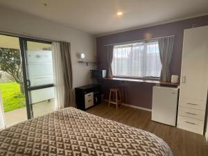a bedroom with a bed and a window at Self check-in sleepout with bathroom in Te Miro