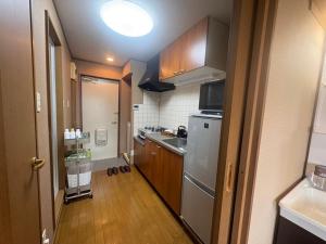 a small kitchen with a sink and a refrigerator at サザンヒルズガーデン in Fujikawaguchiko