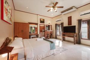 a bedroom with a bed and a flat screen tv at Palm Village in Rawai Beach