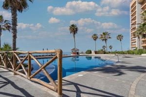 einen Pool mit einem Holzzaun und Palmen in der Unterkunft Sonoran Sun in Campo del Medio