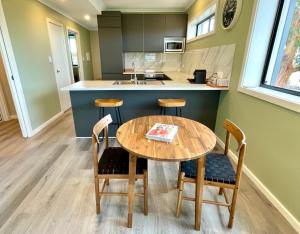 a kitchen with a wooden table and chairs at Apartments on Centenary in Kingscote