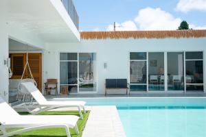 a villa with a swimming pool and two lounge chairs at Prava in Yonaha +33 photos