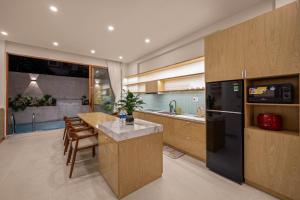 a kitchen with a black refrigerator and a table at Serenity Villa - Near My Khe Beach & City Center by The Key in Da Nang
