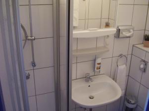 a small bathroom with a sink and a mirror at City Hotel Gifhorn in Gifhorn +15 photos