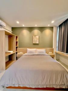 a bedroom with a large bed with a green wall at New Villa at Haadrin in Haad Rin