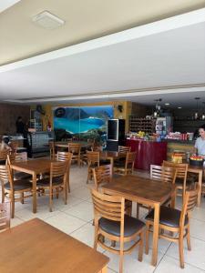 a dining room with wooden tables and chairs at Arraial do Cabo RJ - Golden Lake in Arraial do Cabo