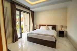 una camera da letto con un letto e una grande finestra di Pondok Manik Uma a Tabanan Altre 22 foto