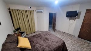 a bedroom with a bed and a flat screen tv at Hostal Oasis del Refugio in Salta