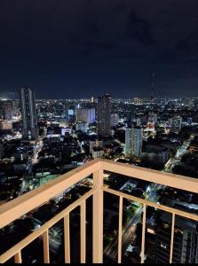 a view of a city skyline at night at Sky Lux Suite by Elnora at Victoria Sports Tower Kamuning Edsa Southbound in Manila