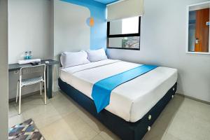 a bedroom with a bed with a desk and a window at Bale Resident in Jakarta