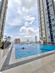 a swimming pool in the middle of two tall buildings at Sky Lux Suite by Elnora at Victoria Sports Tower Kamuning Edsa Southbound in Manila
