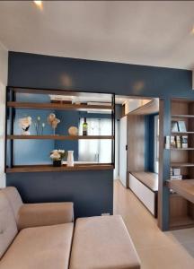 a living room with a couch and a blue wall at Sky Lux Suite by Elnora at Victoria Sports Tower Kamuning Edsa Southbound in Manila